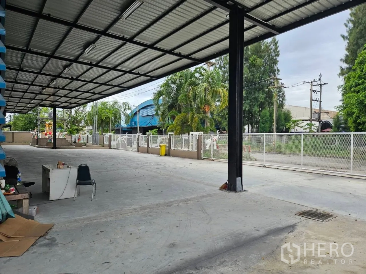 โรงงาน for rent in Si Racha, Chon Buri - ทางวิ่งใต้กันสาดกว้าง พร้อมรั้วรอบและต้นปาล์มริมแนวที่ดิน