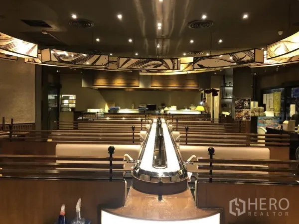 พื้นที่ขายปลีก ให้เช่าในKhlong Toei, Bangkok - ซูชิสายพานพาดกลางห้อง ล้อมด้วยที่นั่งบูธและครัวเปิดด้านหลัง