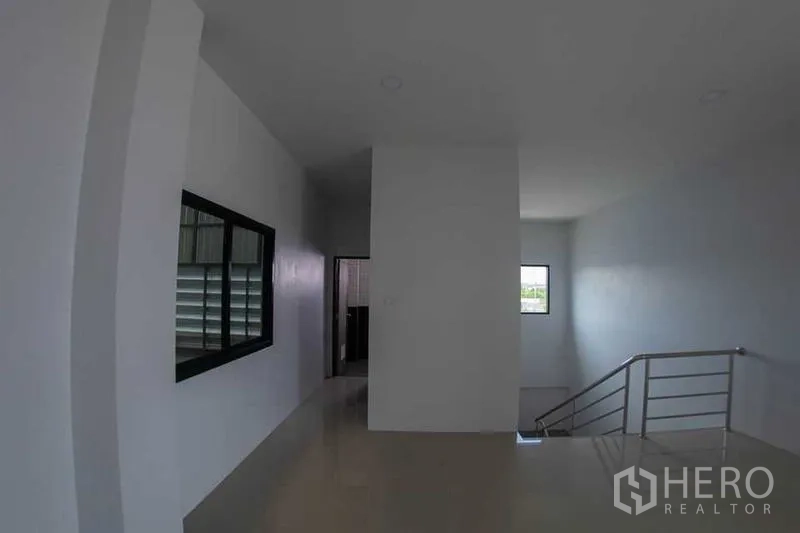Warehouse for sale in Krathum Baen, Samut Sakhon - Minimal office landing with interior window and stainless-steel stair railing.