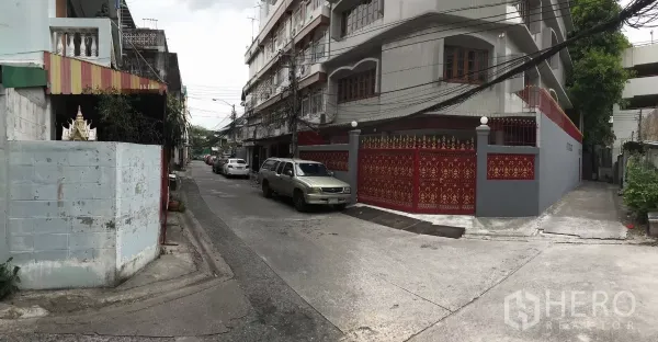 Home Office for rent in Dusit, Bangkok - Quiet residential lane showing the property’s red ornamental fence and neighborhood streetscape.