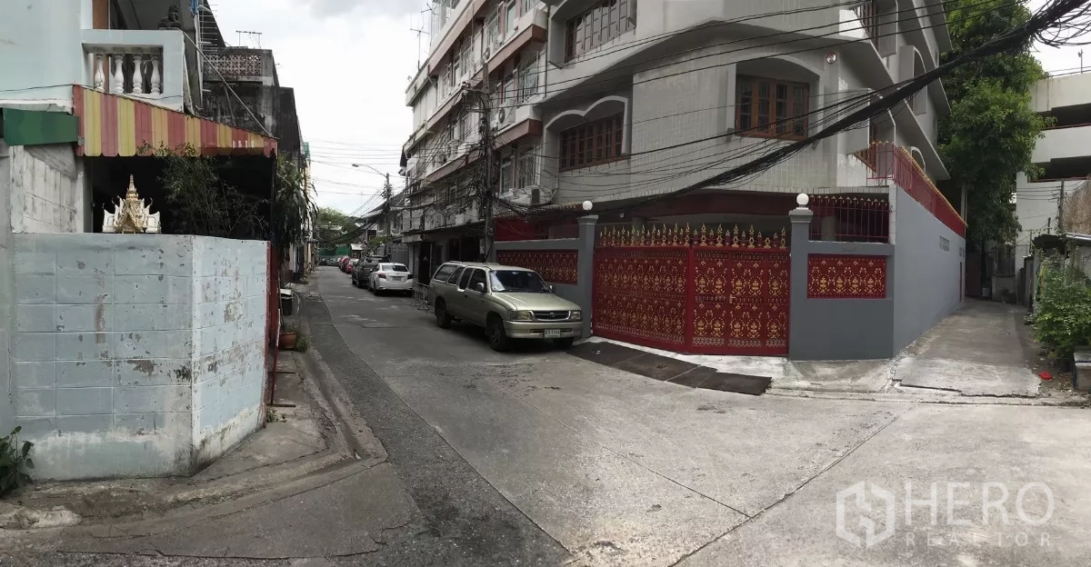 Home Office for rent in Dusit, Bangkok - Quiet residential lane showing the property’s red ornamental fence and neighborhood streetscape.