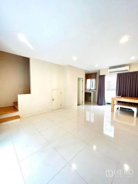 ทาวน์เฮาส์ ขายในBang Kapi, Bangkok - โถงนั่งเล่นชั้นล่าง พื้นกระเบื้องมันวาว บันได และทางเข้าครัว