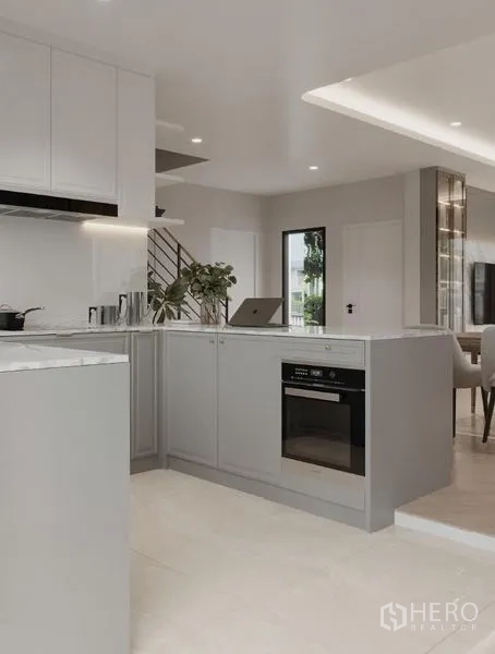 Detached House for rent in Bang Phli, Samut Prakan - Close-up of kitchen peninsula with built-in oven and soft gray cabinetry.