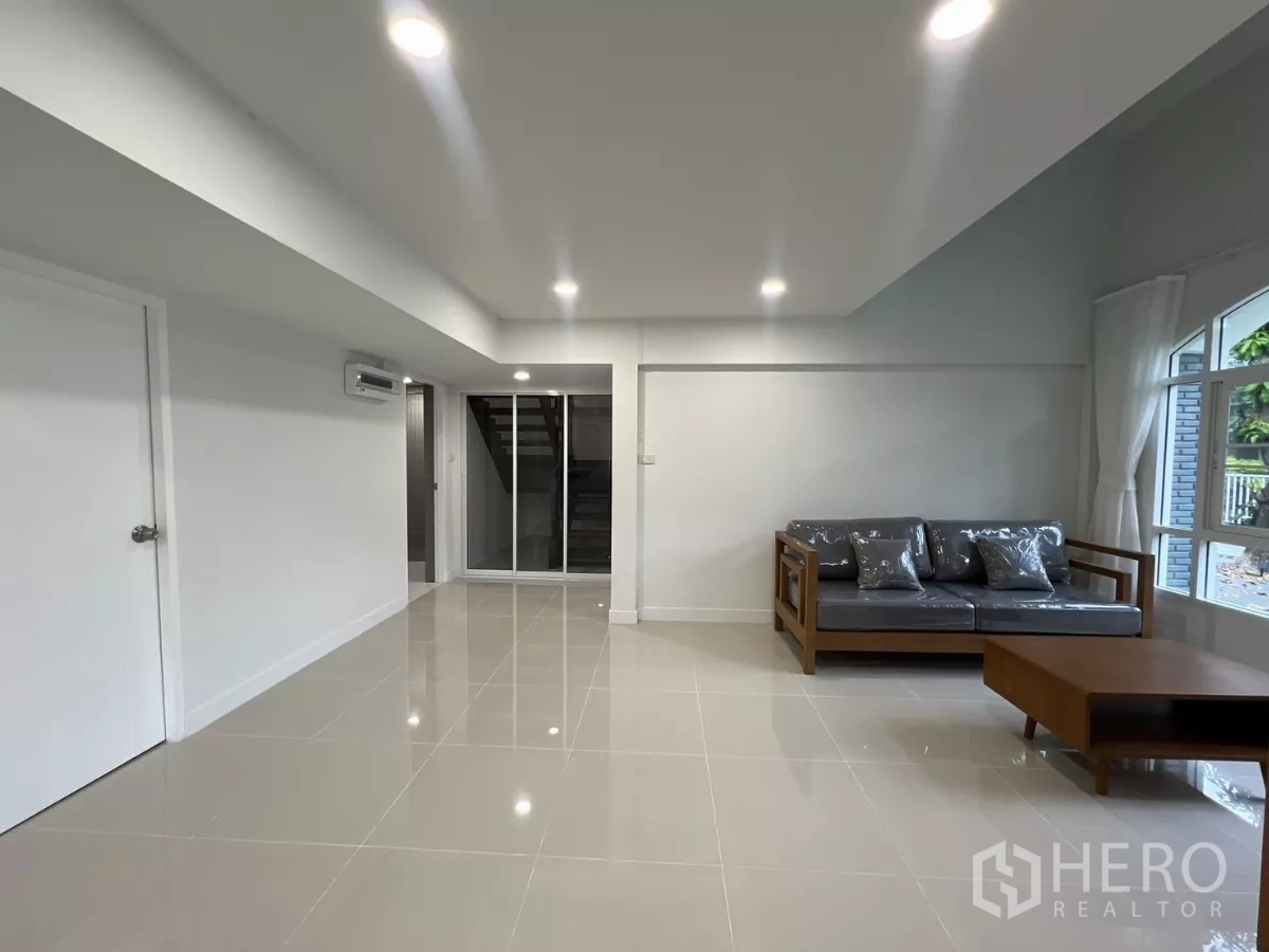 Detached House for rent in Saphan Sung, Bangkok - Ground floor living space with staircase access and glossy tiled flooring.
