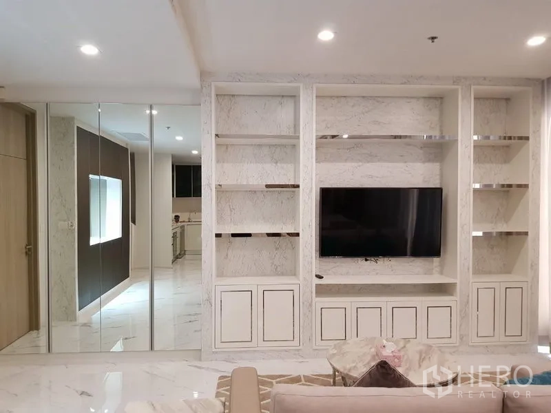 คอนโด ให้เช่าในPathum Wan, Bangkok - ผนังทีวีพร้อมชั้นหินอ่อนและตู้เสื้อผ้าบานกระจกในห้องนั่งเล่นหรู