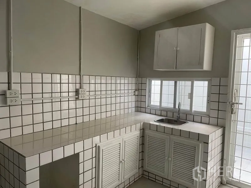 独立式住宅 出租在Huai Khwang, Bangkok - 紧凑厨房，瓷砖台面与白色橱柜及水槽