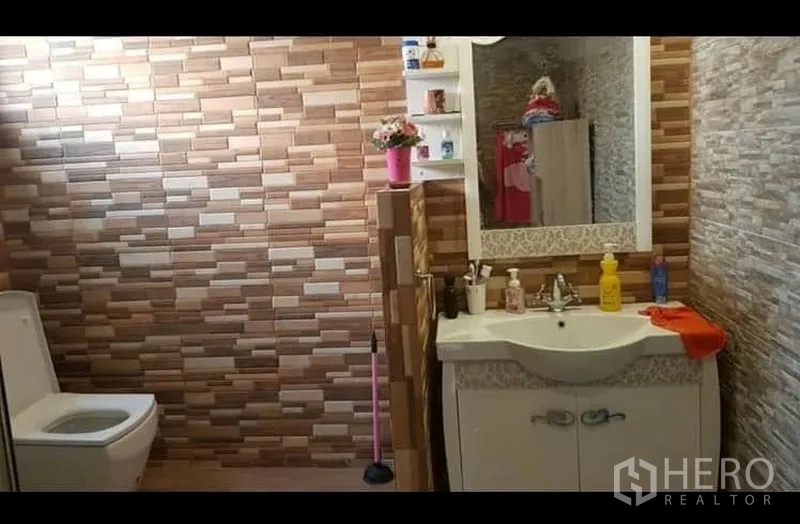 คอนโด ให้เช่าหรือขายในWatthana, Bangkok - ห้องน้ำปูกระเบื้องผนังลายสีน้ำตาล เคาน์เตอร์อ่างล้างหน้าพร้อมกระจกและโถสุขภัณฑ์