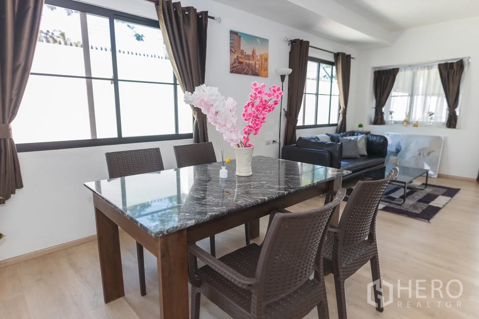 Townhouse for rent in Bang Phli, Samut Prakan - Dining area with marble-top table and four chairs by large windows.
