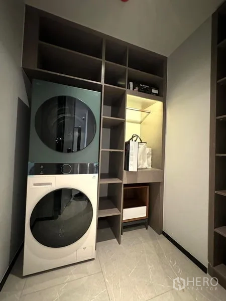 Condominium for rent in Watthana, Bangkok - Laundry room with stacked washer and dryer and built-in storage.