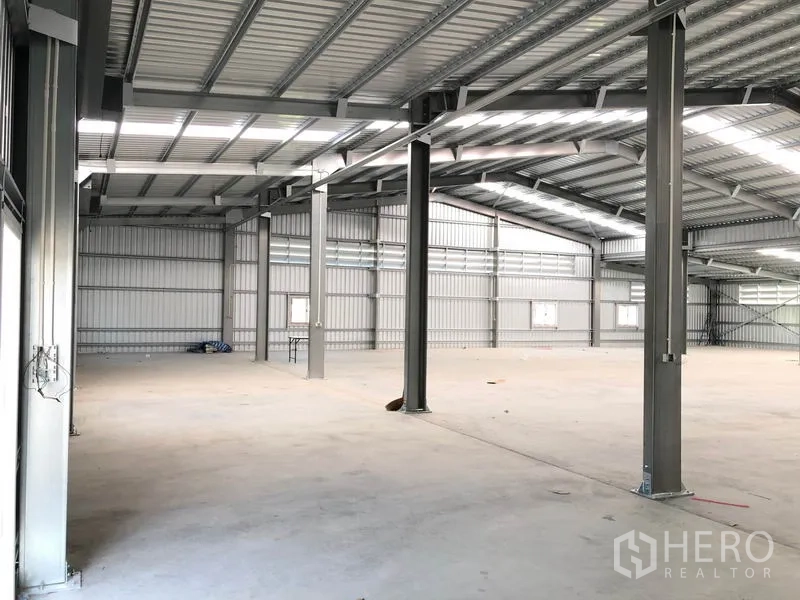 Warehouse for rent in Pak Kret, Nonthaburi - Open-plan storage hall with insulated metal roof and skylights for natural light.