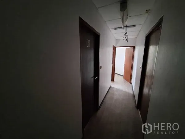 Office Space for rent in Watthana, Bangkok - Dim hallway with several wooden doors leading to private rooms.