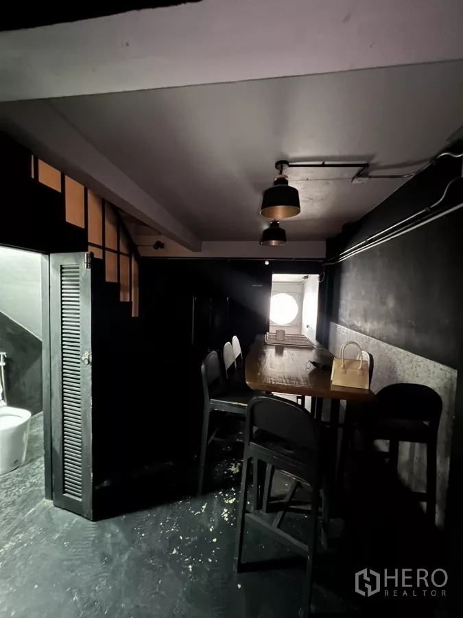 店屋 出租在Watthana, Bangkok - 楼梯下用餐角，高桌与吊灯，旁有卫生间。
