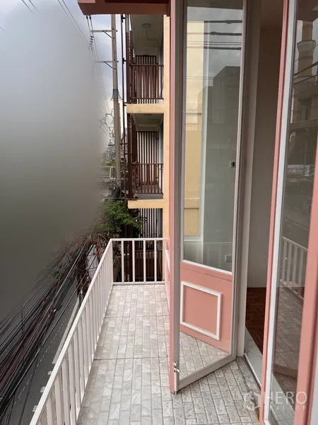 อาคารพาณิชย์ ให้เช่าหรือขายในWatthana, Bangkok - ระเบียงแคบ ราวสีขาว และบานประตูกรอบสีชมพู มองเห็นอาคารข้างเคียง