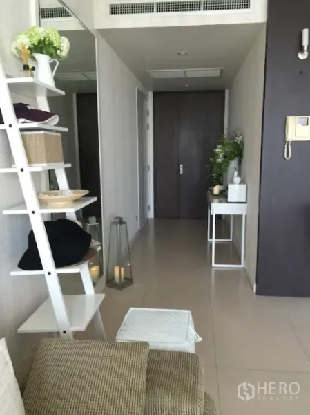 公寓 出租或出售在Ratchathewi, Bangkok - 入户走廊，白色梯形置物架、玄关桌与深色木门。