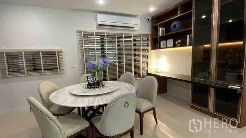 Detached House for rent or sale in Prawet, Bangkok - Cozy dining nook with round marble table and built-in shelves with lighting.