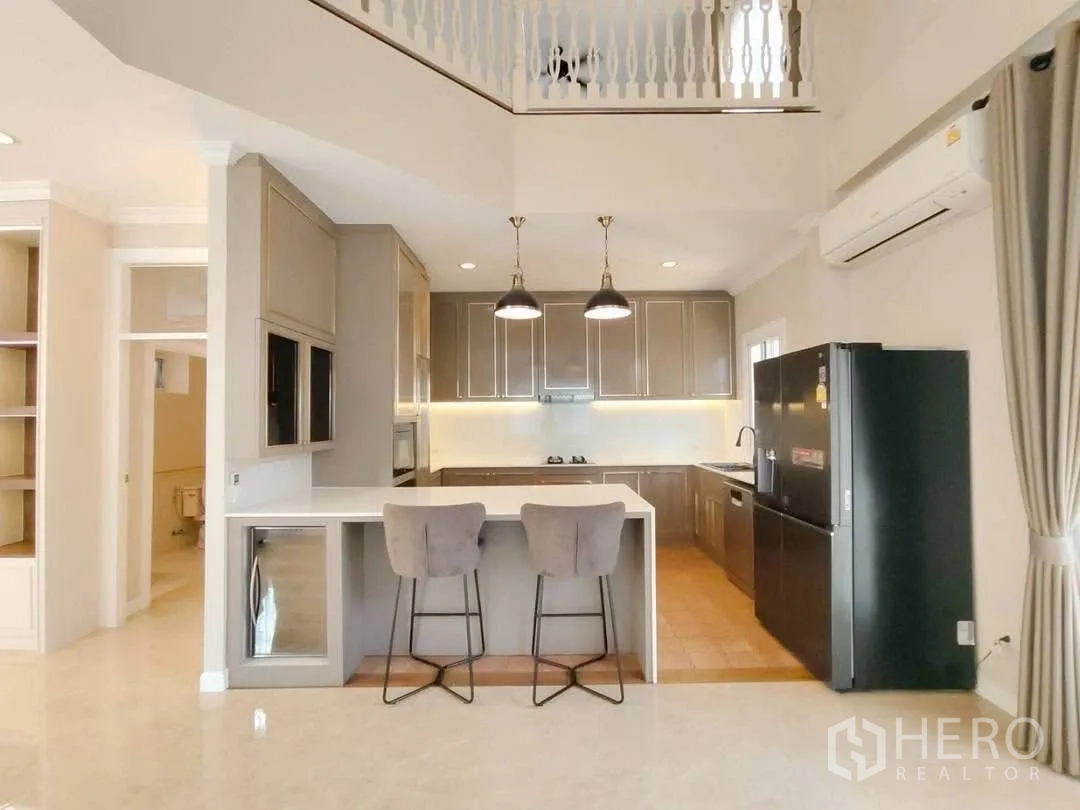 Detached House for rent in Bang Na, Bangkok - Open kitchen with breakfast bar and pendant lights next to living area.