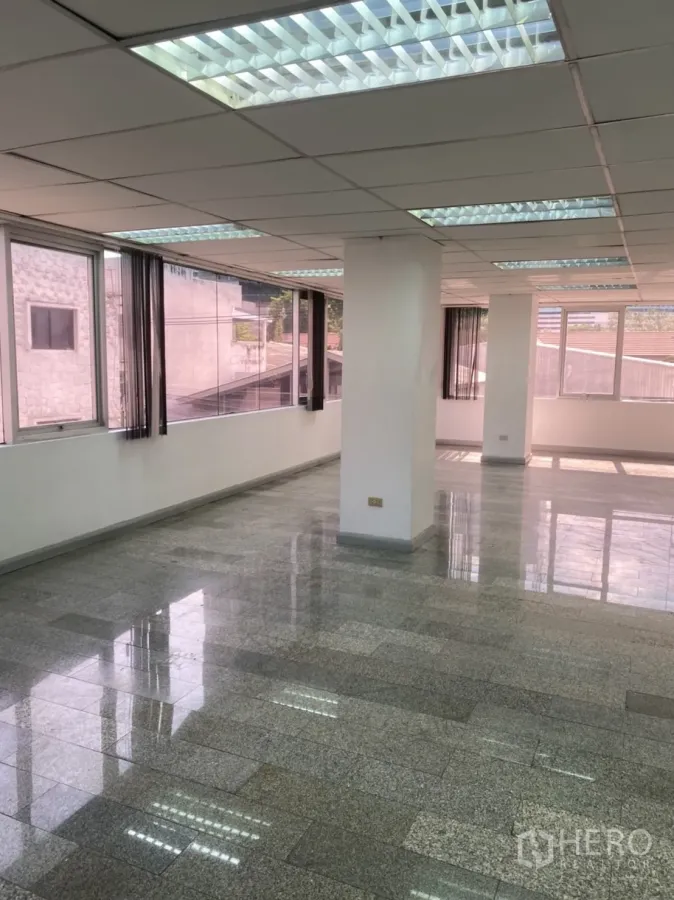 Office Space for rent in Khlong Toei, Bangkok - Bright open‑plan office with large windows, granite tile floors and fluorescent ceiling lights near BTS Thonglor.