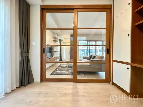 独立式住宅 出租或出售在Prawet, Bangkok - 木框玻璃推门连接多功能房与客厅。