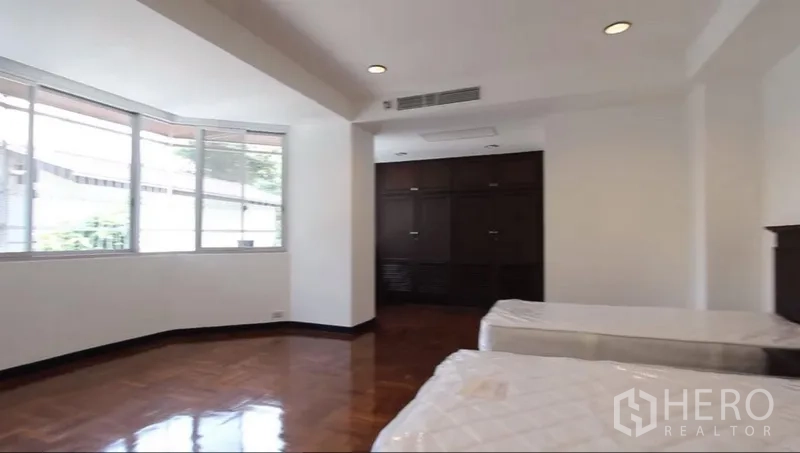 อพาร์ทเมนท์ ให้เช่าในKhlong Toei, Bangkok - ห้องนอนมุมกว้าง เตียงคู่ หน้าต่างบานใหญ่ และตู้เสื้อผ้าบิวท์อิน