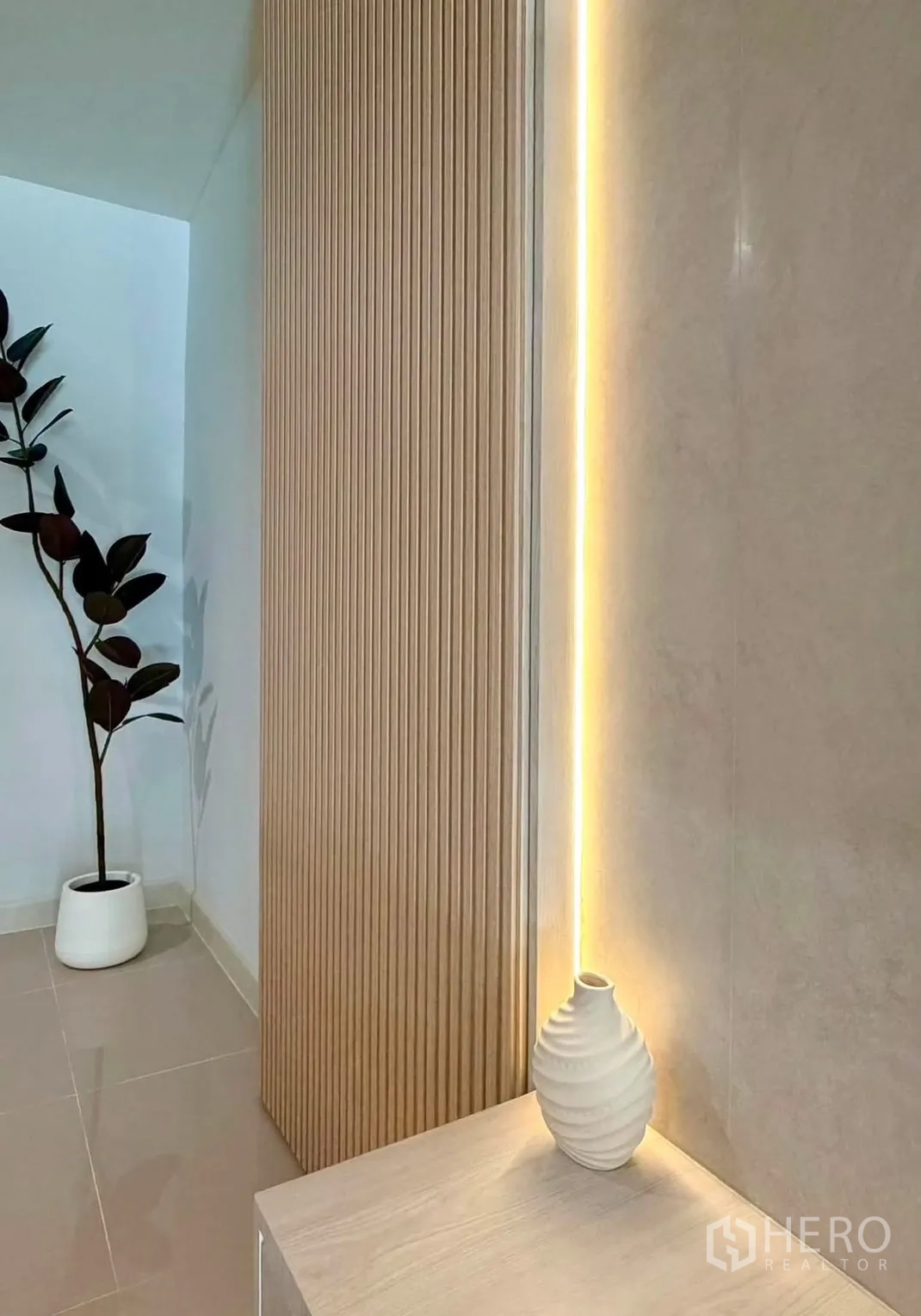 Townhouse for rent in Bang Phli, Samut Prakan - Interior detail with a wood slat feature wall, warm LED strip lighting, and a potted plant.