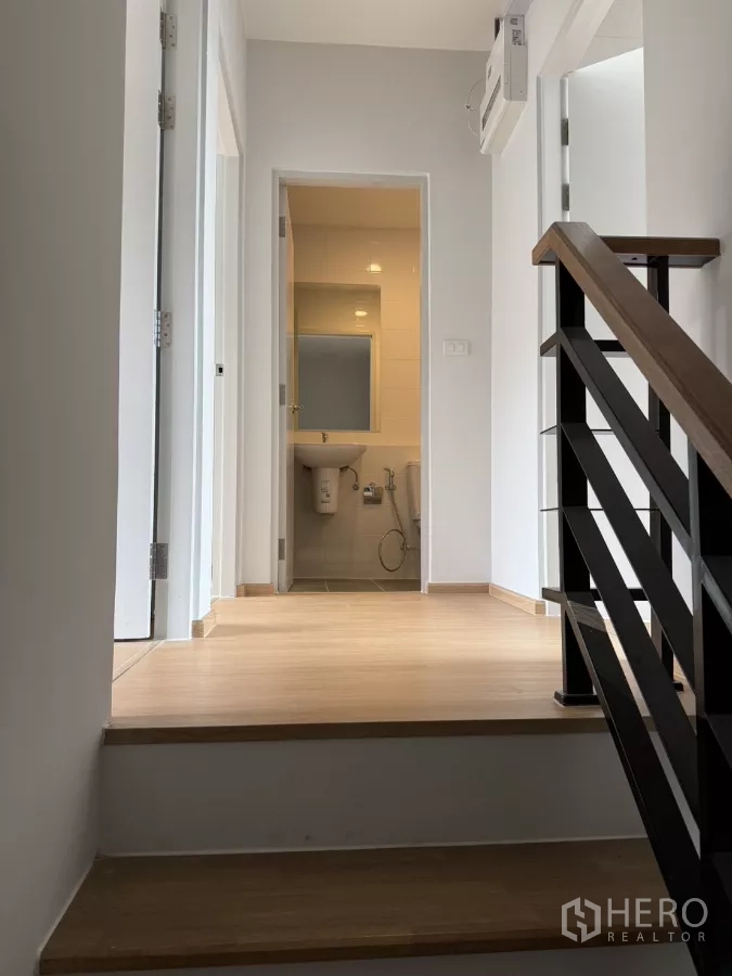 Townhouse for rent in Bang Phli, Samut Prakan - Upper hallway with wooden steps leading to bedrooms and a bathroom.