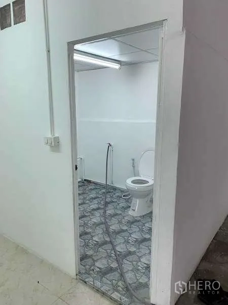 货栈 出租在Mueang Pathum Thani, Pathum Thani - 仓库卫生间，坐便器、喷枪及花纹地砖。
