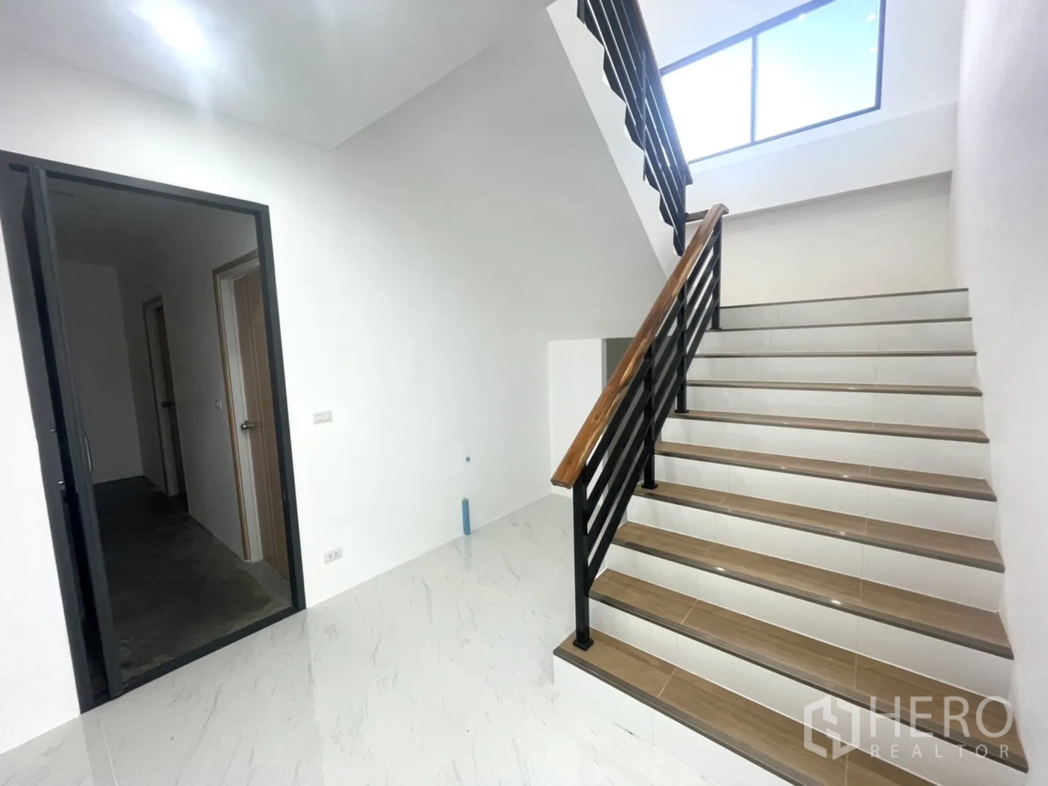 工厂 出租或出售在Bang Yai, Nonthaburi - 整洁的楼梯间，木质扶手与黑色金属栏杆通往办公室。