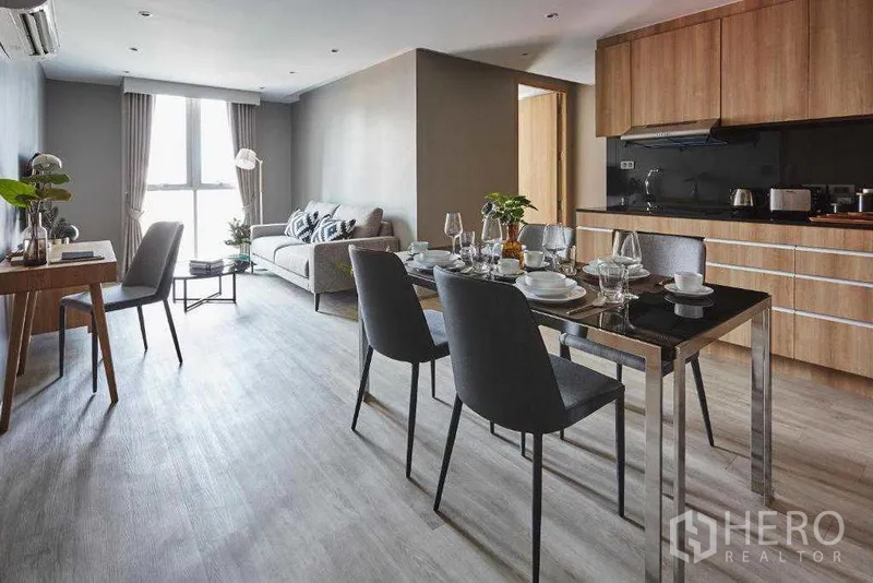 อพาร์ทเมนท์ ให้เช่าในKhlong Toei, Bangkok - พื้นที่รับแขก–รับประทานอาหาร–ครัวแบบเปิด ตู้บานไม้และโต๊ะอาหาร 4 ที่นั่ง