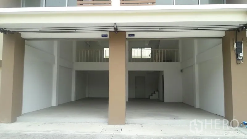 Office Space for sale in Khlong Luang, Pathum Thani - Ground‑floor open plan space with high ceiling, twin bays and mezzanine level beneath raised roller doors.
