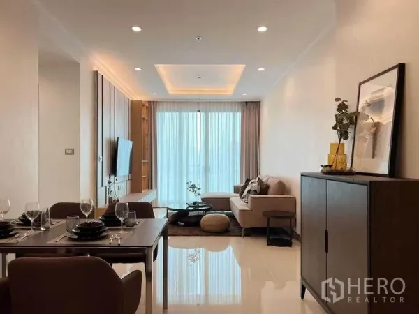 公寓 出租在Watthana, Bangkok - 开放式客餐厅，沙发、电视背景墙与通透阳台玻璃。