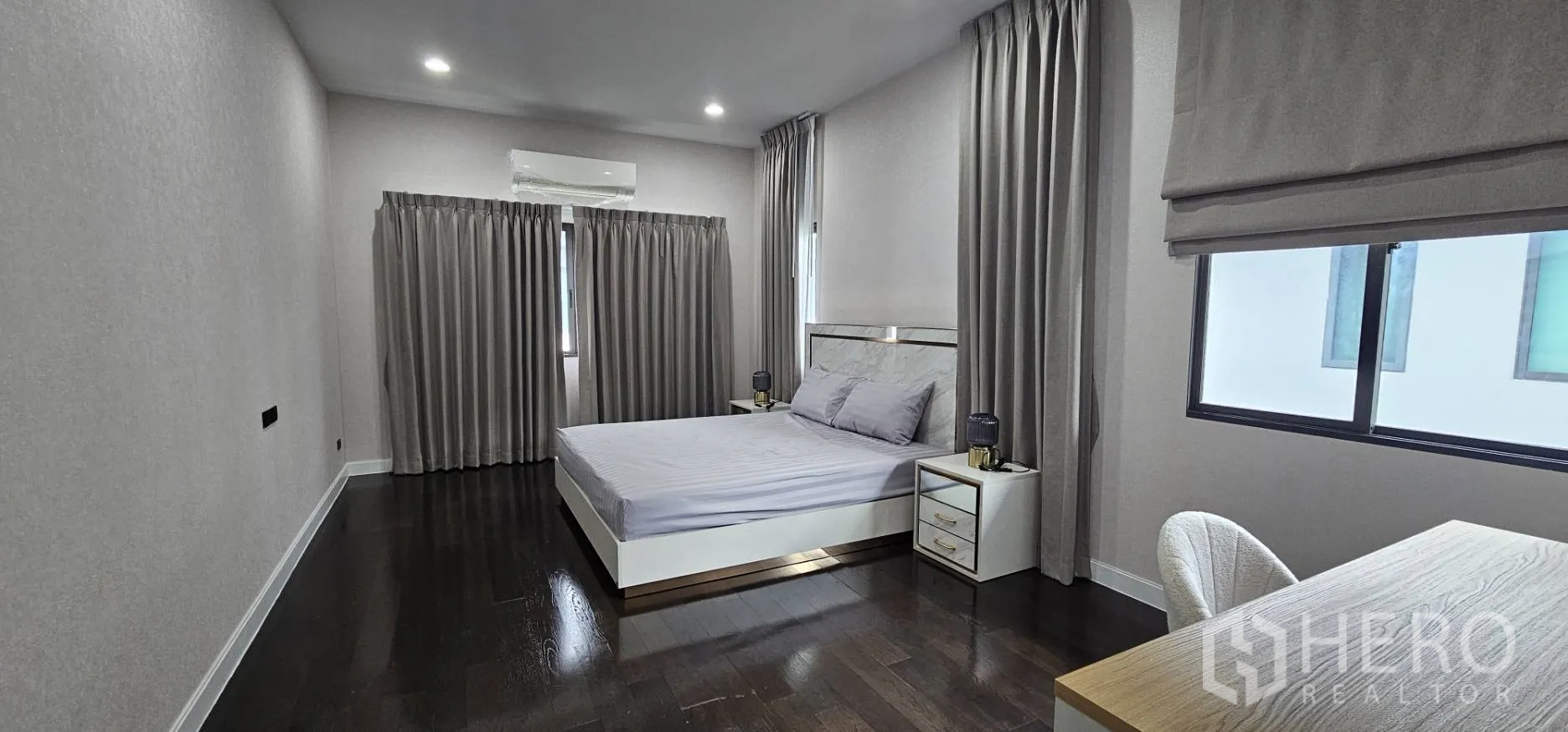 Detached House for rent in Bang Kapi, Bangkok - Large corner bedroom with desk, nightstands and draped windows.