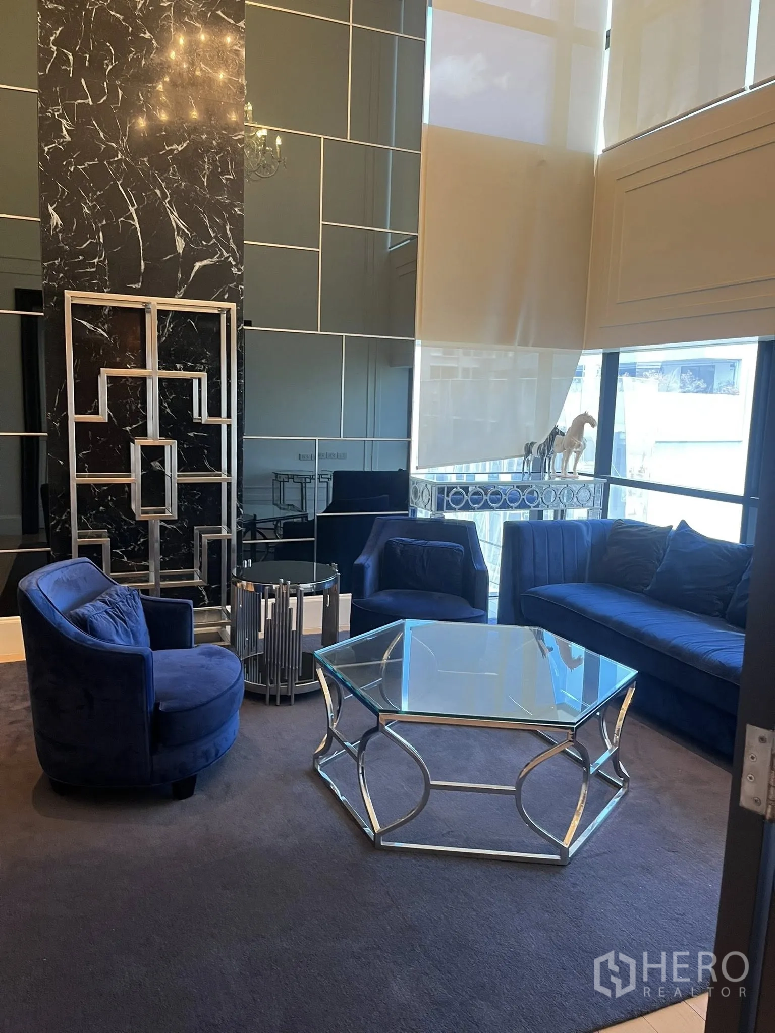 Home Office for rent in Watthana, Bangkok - Stylish sitting area with blue armchairs, a sofa, and a glass coffee table.