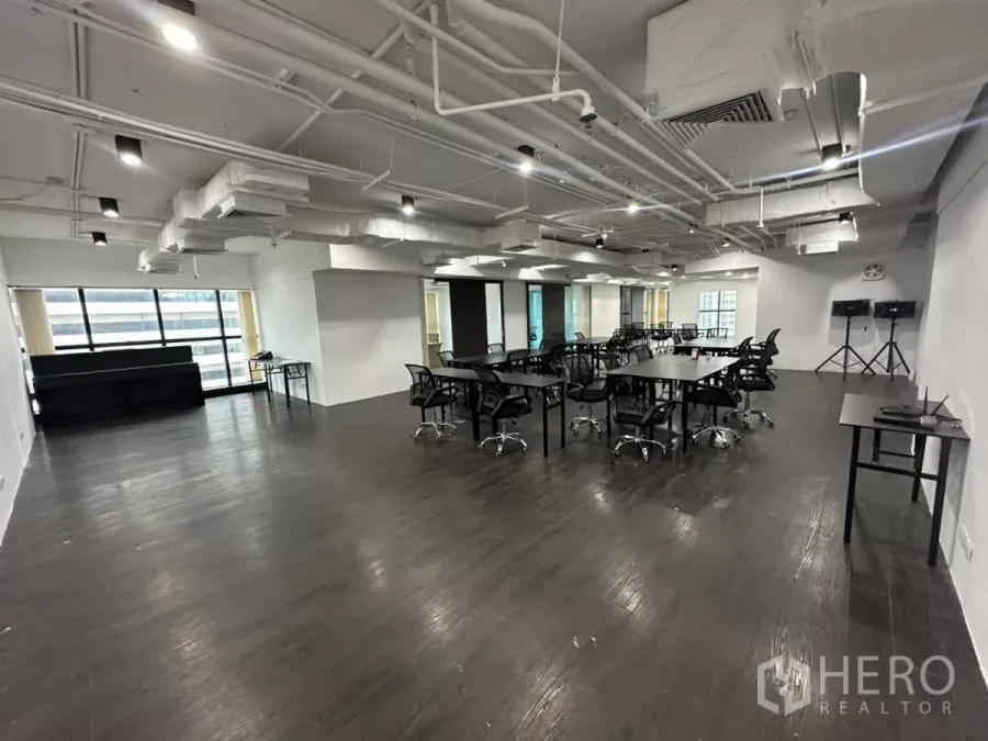 办公空间 出租在Watthana, Bangkok - 开放式办公区，深色地板，外露管道吊顶与大幅城市景观窗。