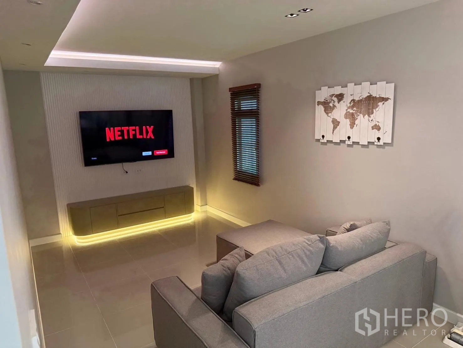Detached House for rent in Prawet, Bangkok - Cozy media room with wall-mounted TV and sectional sofa.