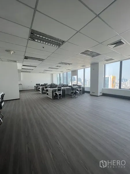 Office Space for rent in Huai Khwang, Bangkok - Bright open office area with workstations by wide windows and wood-look flooring.