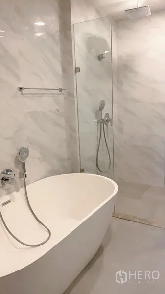 公寓 出租在Watthana, Bangkok - 现代卫浴，独立式浴缸与玻璃淋浴间，墙面大理石纹。
