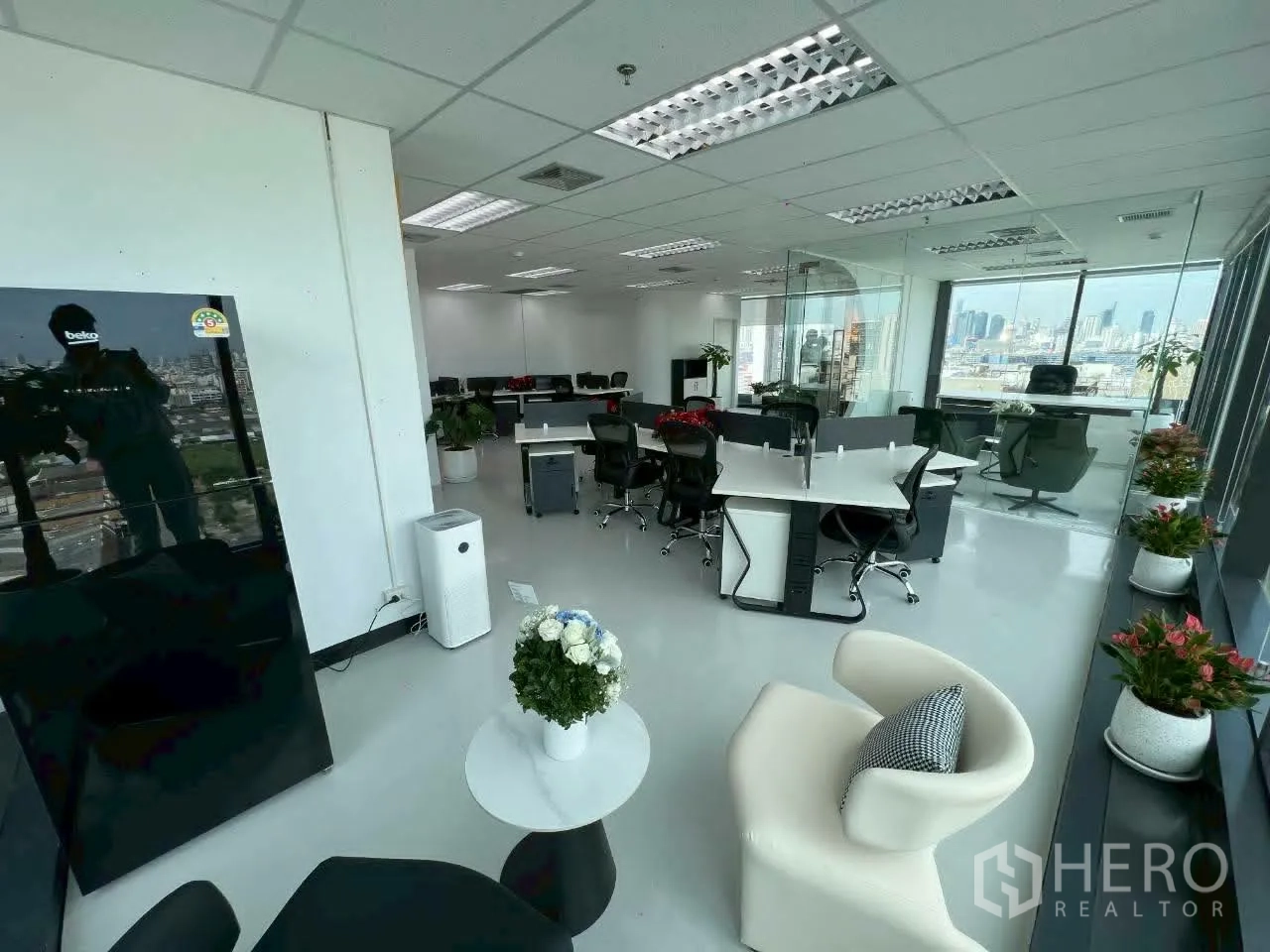 Office Space for rent in Din Daeng, Bangkok - Open workspace with bench desks, lounge chairs, and city views through wide windows.