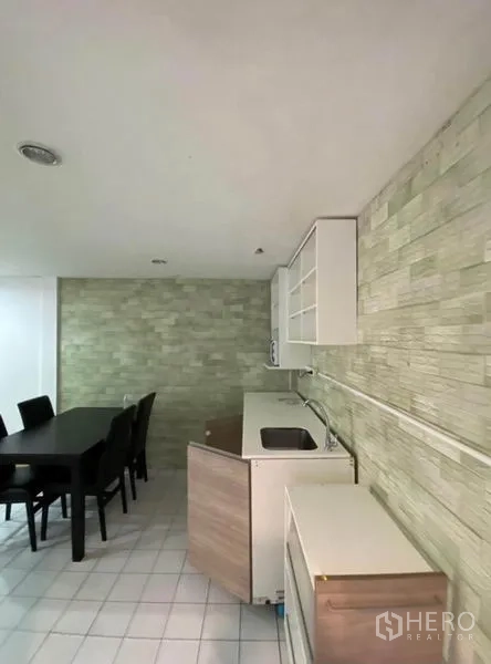 ทาวน์เฮาส์ ให้เช่าในKhlong Toei, Bangkok - ครัวกะทัดรัดพร้อมมุมทานอาหาร ผนังลายหิน และตู้เก็บของสีขาว