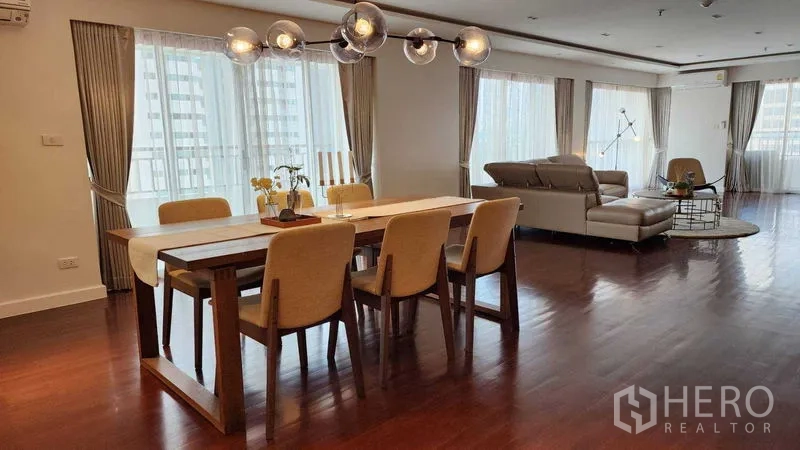 คอนโด ให้เช่าในSathon, Bangkok - โถงนั่งเล่นและทานอาหารแบบโอเพ่น พร้อมหน้าต่างรอบด้าน โคมไฟแชนเดอเลียร์ และโซฟาหนัง