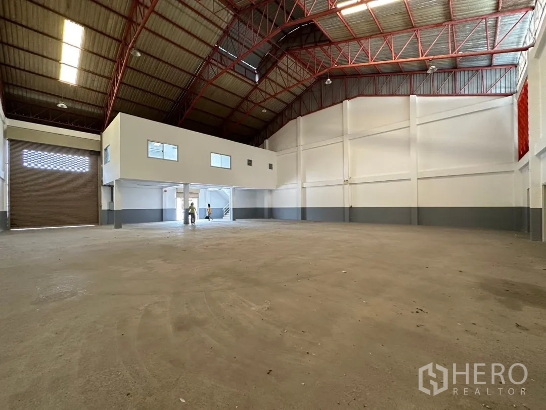 Factory for rent in Bang Sao Thong, Samut Prakan - Warehouse interior showing wide roller shutter entrance and clear loading space.