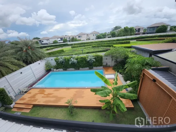 Detached House for rent in Bang Phli, Samut Prakan - Aerial view of the pool, timber deck and tall privacy hedges with the neighborhood in the background.
