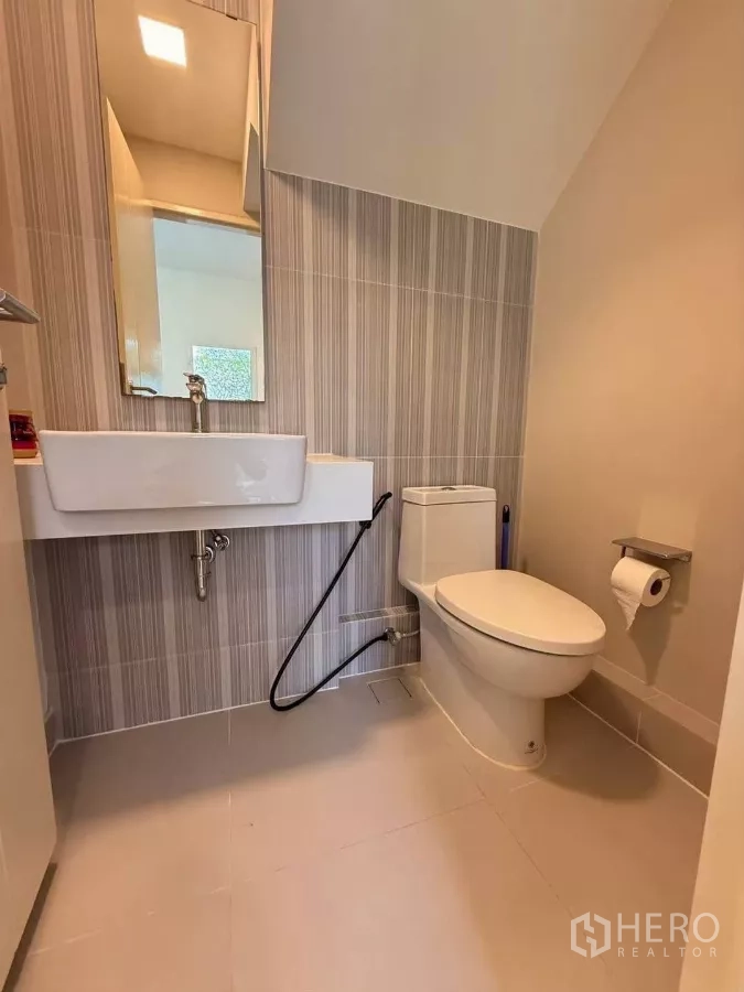 联排别墅 出租在Prawet, Bangkok - 一层盥洗室，带洗手台、坐便和喷枪。