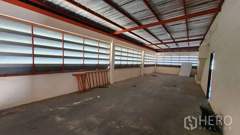Factory for rent in Pak Kret, Nonthaburi - Upper-floor storage area with louvered windows and metal roof