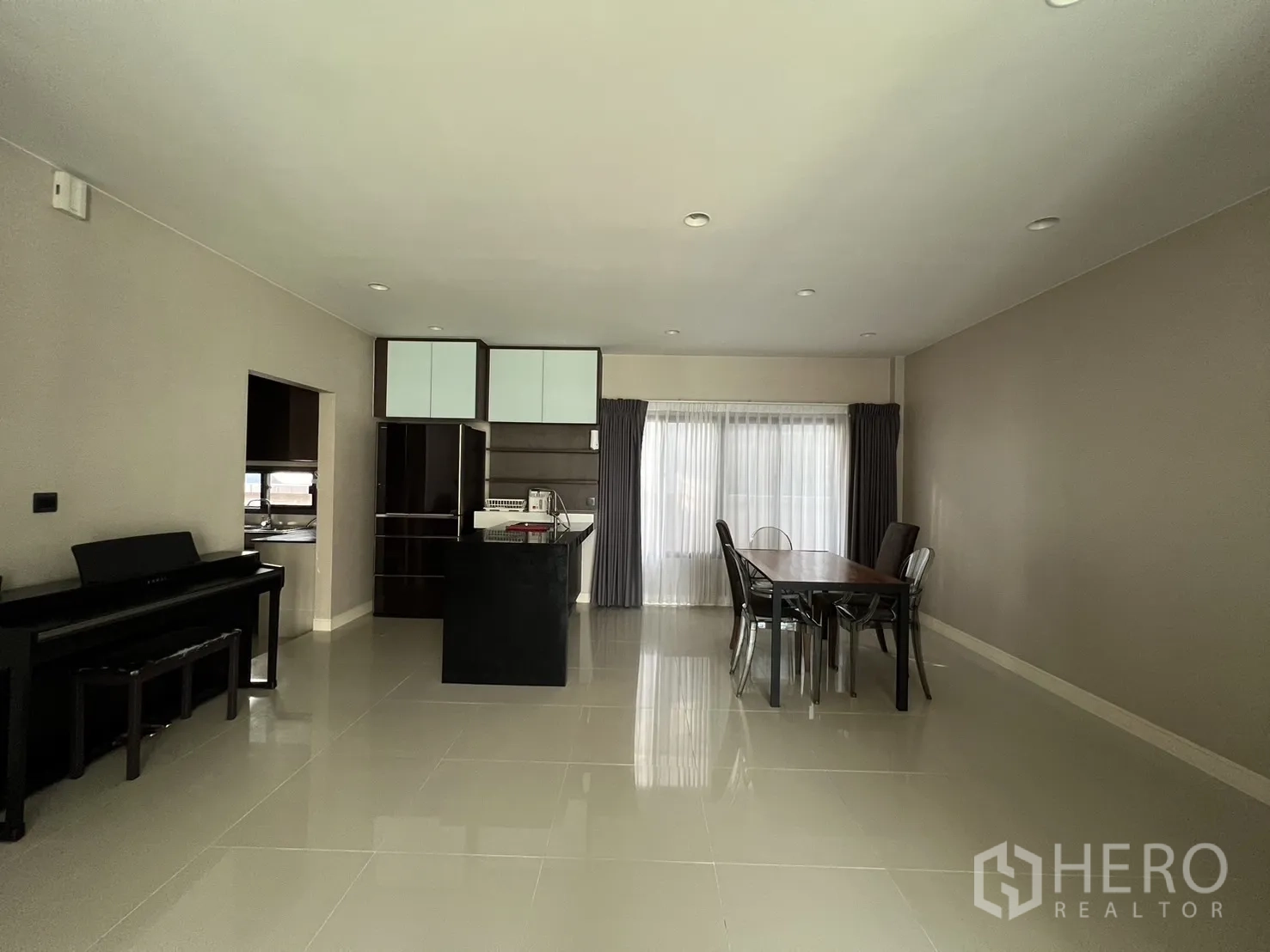 Detached House for rent or sale in Bang Kapi, Bangkok - Open‑plan dining space and pantry with large windows and a piano.