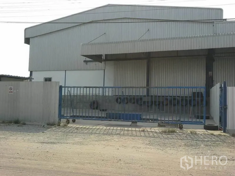 货栈 出租在Chon Buri - 金属外墙仓库外观，带雨棚装卸区与滑动大门