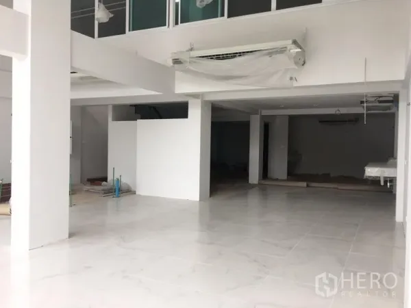 店屋 出租在Bang Na, Bangkok - 店屋一层开放式空间，白色地砖与立柱，带夹层布局，临近BTS Udom Suk。