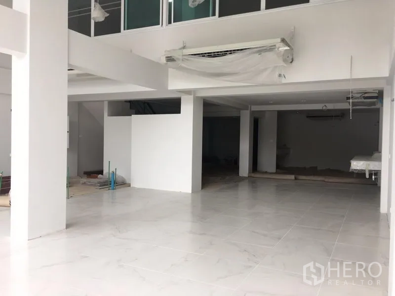 店屋 出租在Bang Na, Bangkok - 店屋一层开放式空间，白色地砖与立柱，带夹层布局，临近BTS Udom Suk。