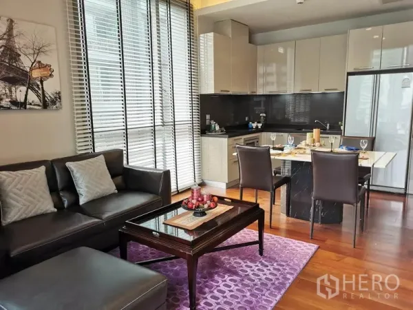 公寓 出租在Watthana, Bangkok - 通罗公寓开放式客厅，真皮沙发、用餐岛台与现代厨房，木地板与落地百叶窗。