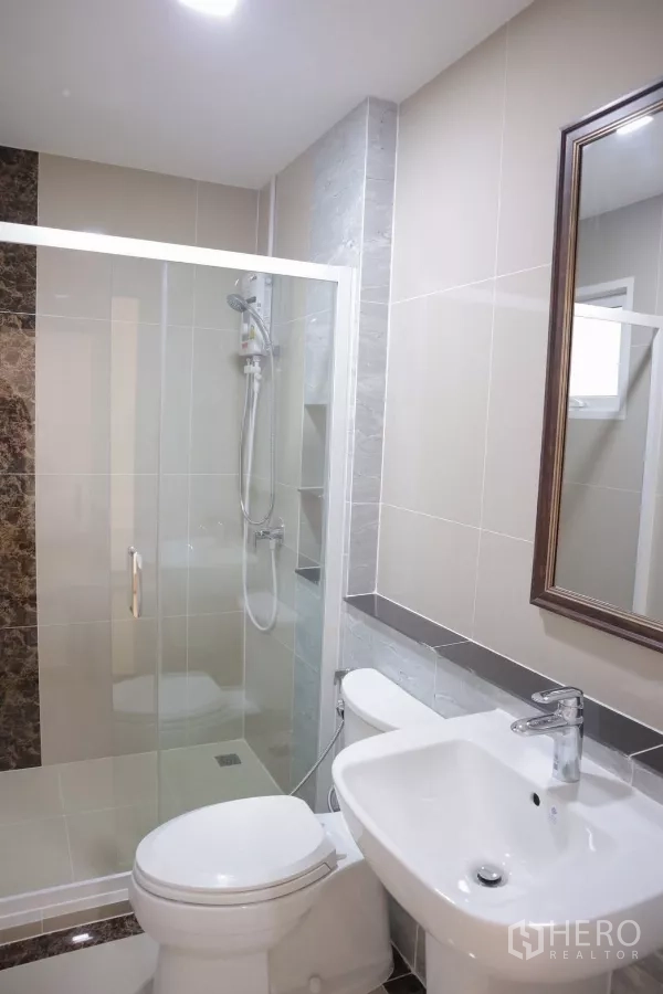 Detached House for rent in Bang Phli, Samut Prakan - Bathroom with glass-enclosed shower, toilet and vanity basin.