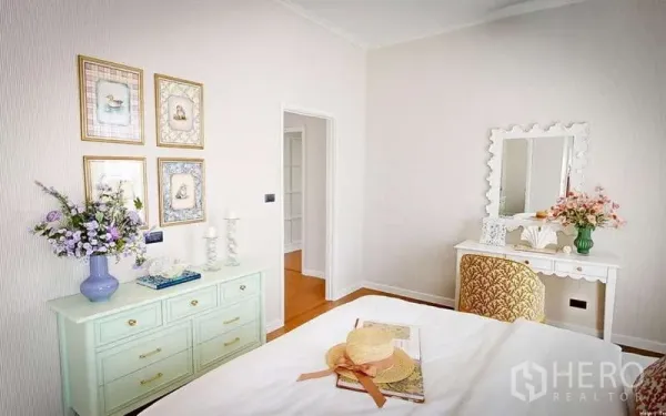 Detached House for rent in Bang Phli, Samut Prakan - Guest bedroom corner with mint dresser, vanity table, framed wall art and floral decor in soft neutrals.